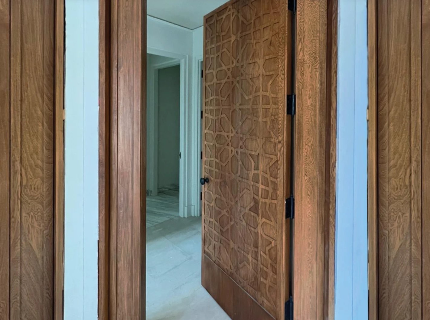 Pivot door carved with an interlocking geometric star lattice